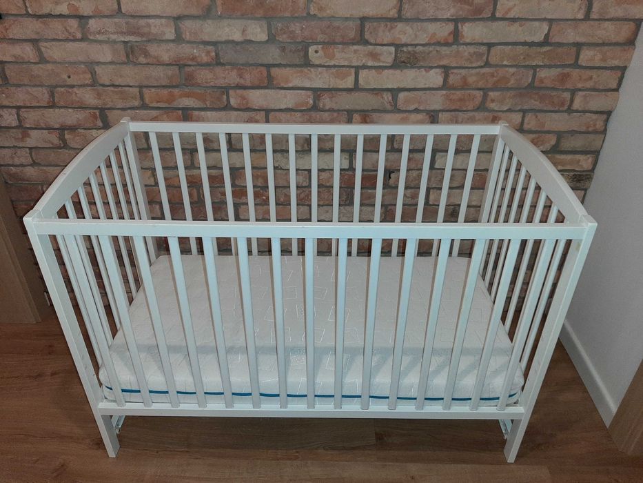 Łóżeczko drewniane z materacem i szuflada.