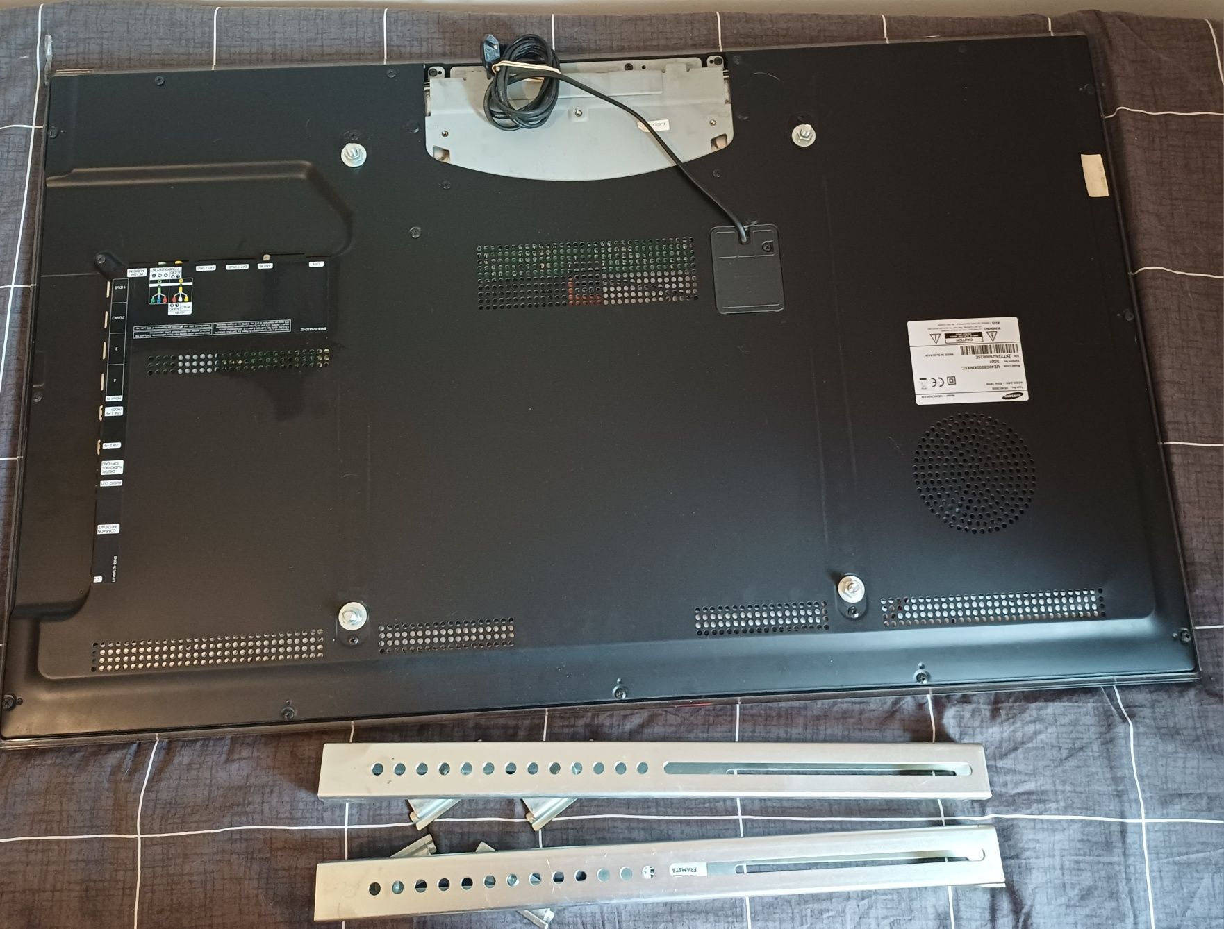 Televisão Samsung  com riscos e suporte.