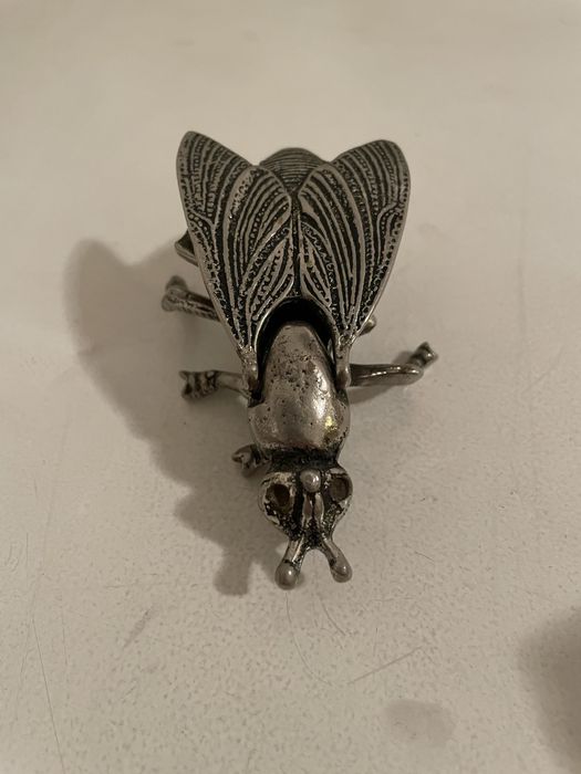 Mosca em metal prateado