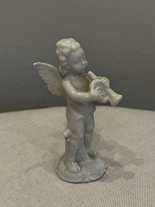Figurka Putto (aniołek) grający na trąbce, porcelana Wagner & Apel.