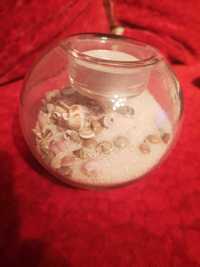 Szklany świecznik z piaskiem i muszelkami