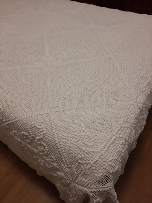 Colcha branca de renda feita à  mão .