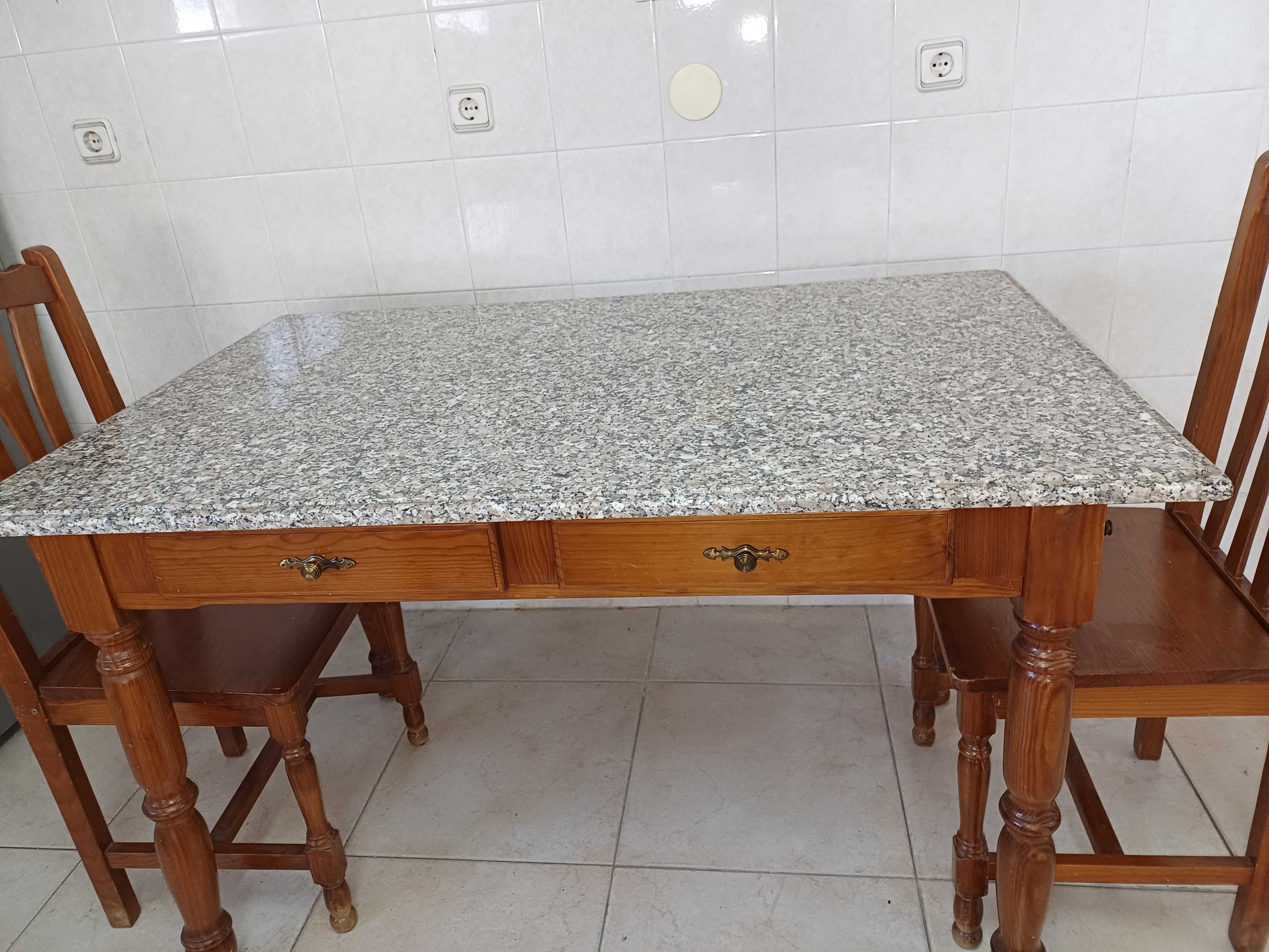 Mesa de cozinha com tampo em granito polido e quatro cadeiras.