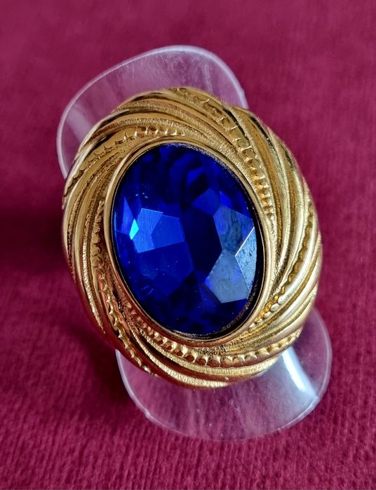 Anel dourado, em aço, com grande pedra oval azulão. T18