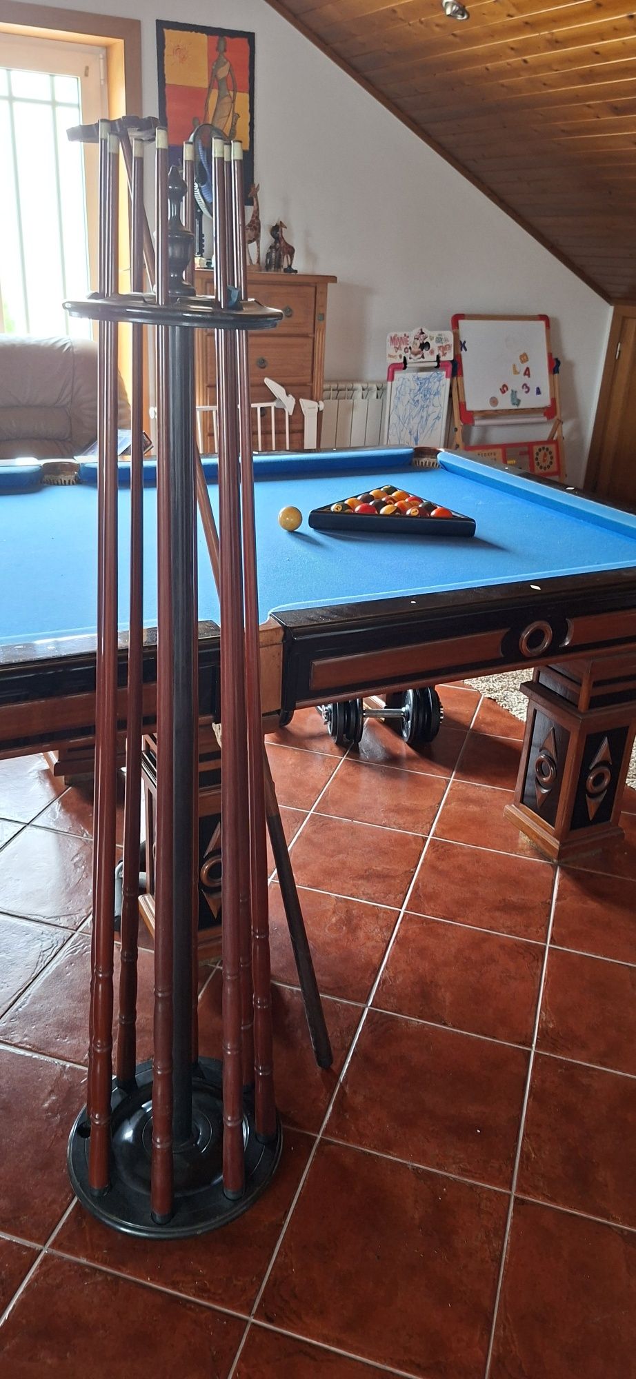 Mesa de bilhar com tacos e bolas
