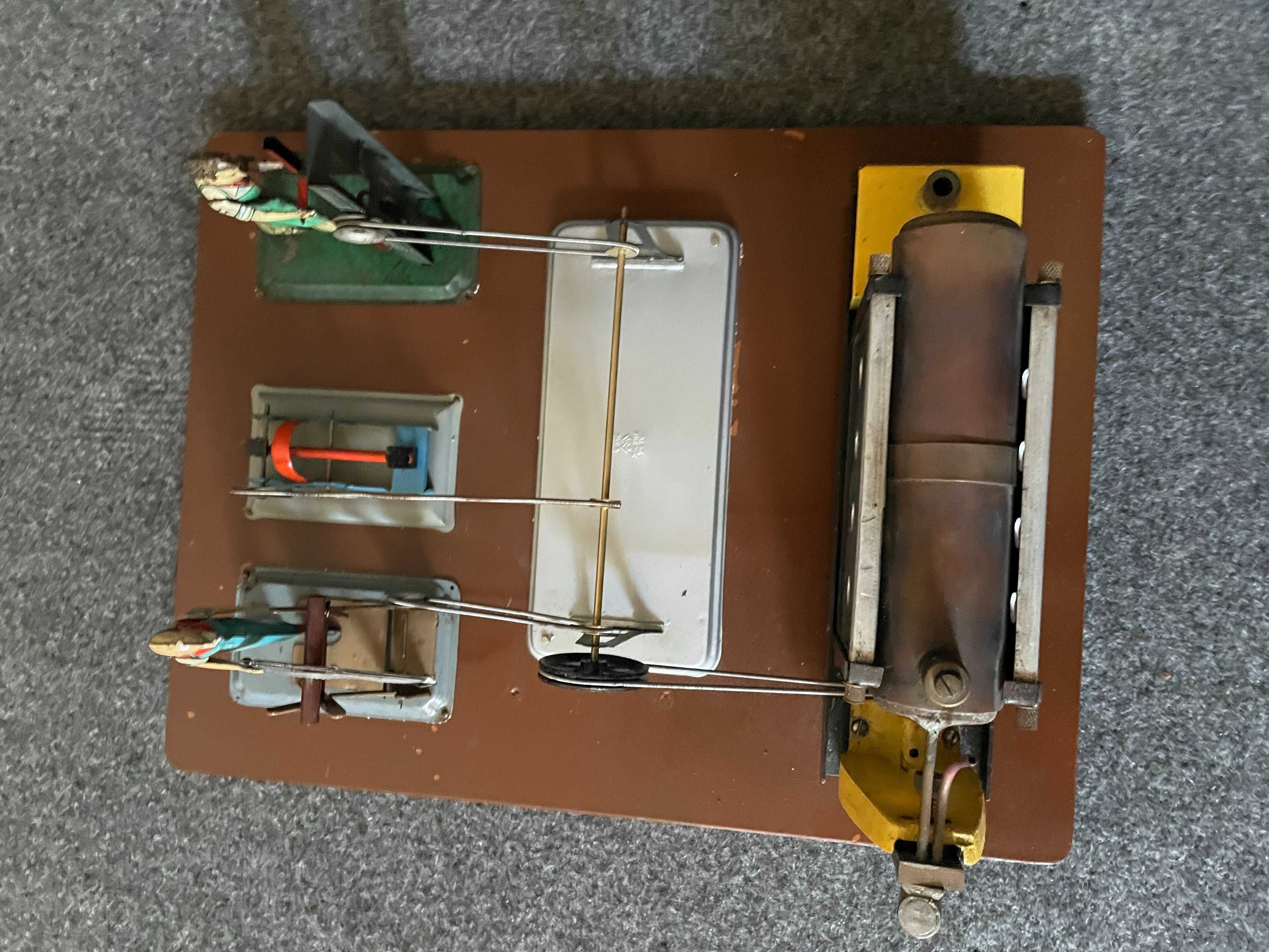 Brinquedo técnico antigo a vapor com bonecos em chapa