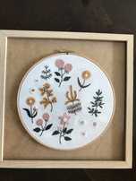 Quadros bordados à mão com motivos de flores.