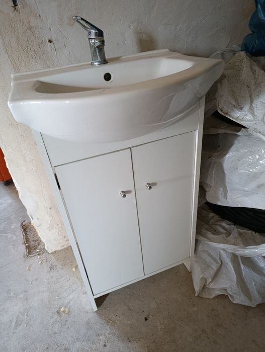 Szafka łazienkowa z umywalką i bateria.