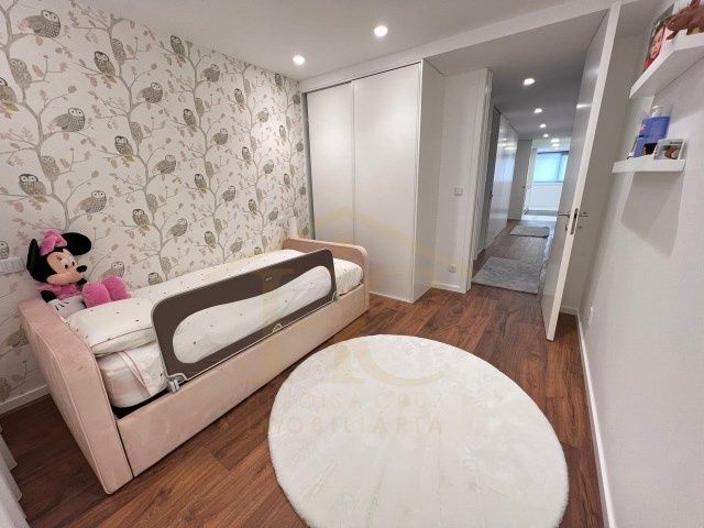 Móveis lacados cinzentos e cama cor de rosa com colchão e estrado