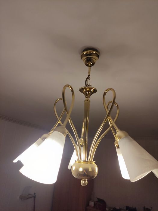 Żyrandol w kolorze złotym ze szklanymi białymi kloszami