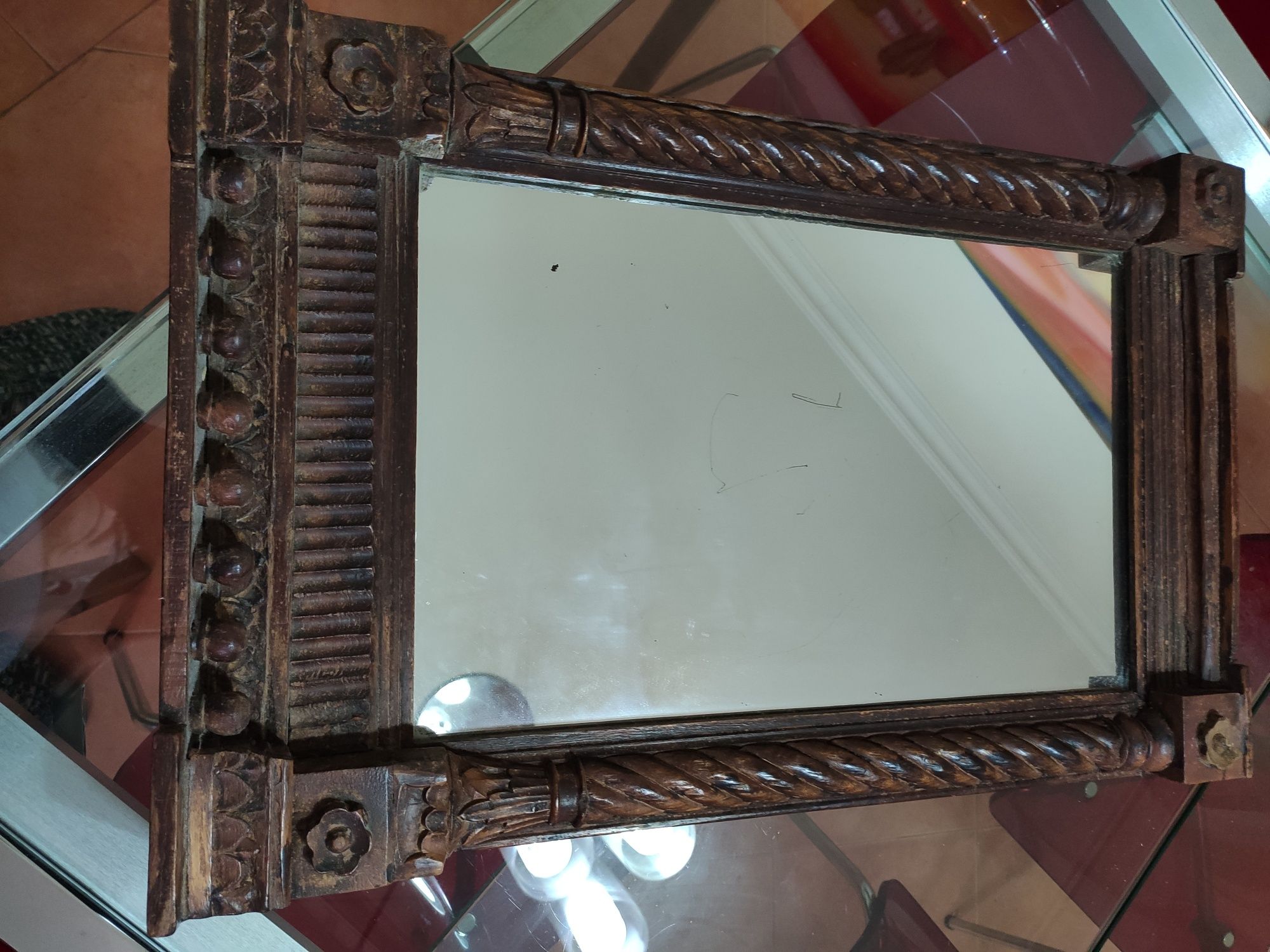 Espelho antigo com moldura em madeira.