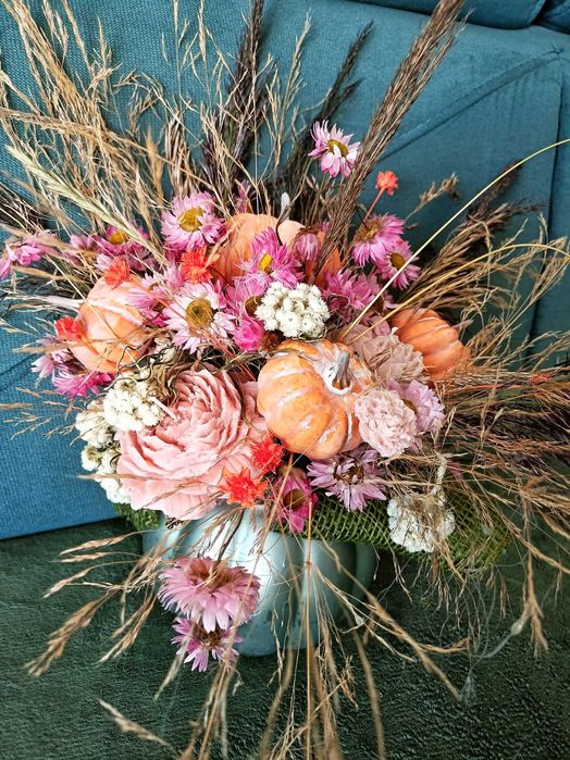 Jesienny stroik w szklanym wazonie dynia ze świecami sojowymi