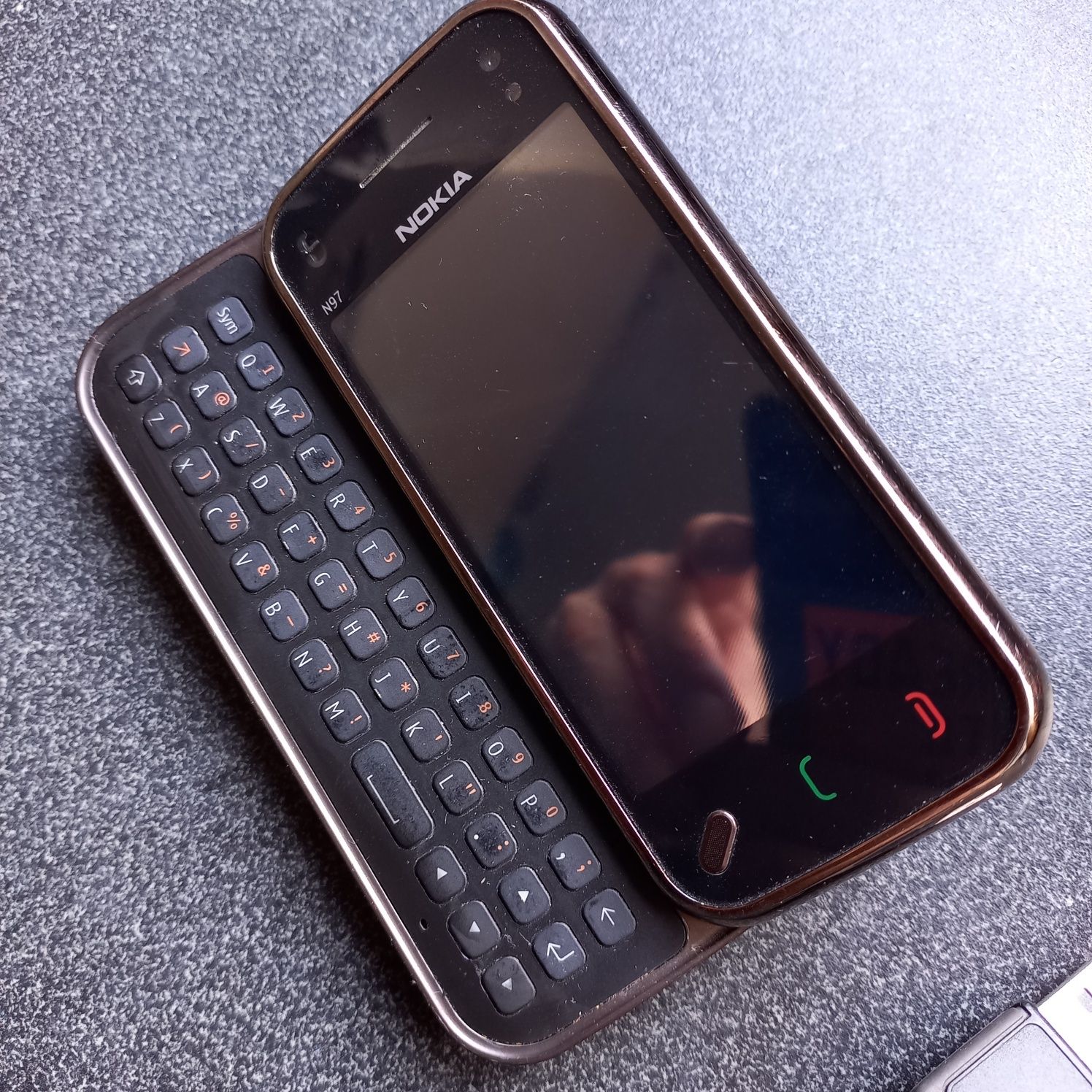 Nokia N97 mini z oryginalnym uchwytem i kablem.