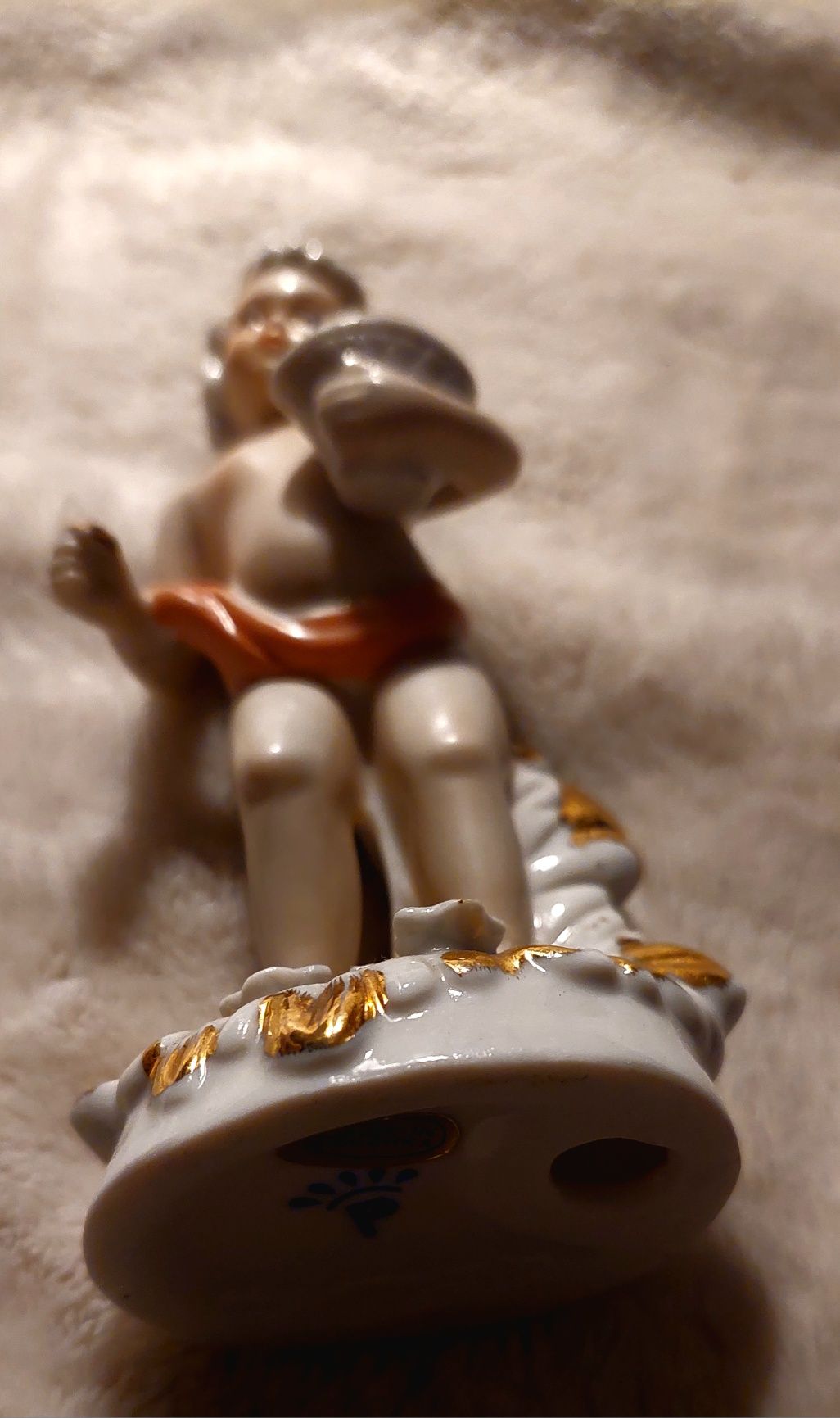 Putto , porcelanowa figurka chłopiec z czerwoną szarfą,sygnowana