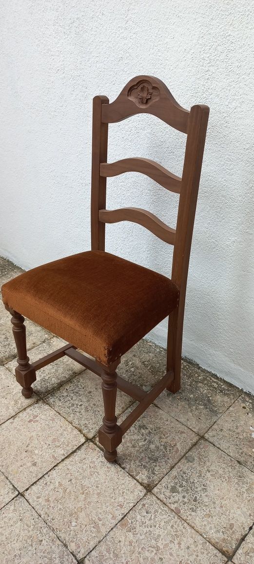 Cadeira em madeira com assento forrado em castanho escuro.