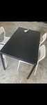 Vendo mesa preta com 4 cadeiras brancas em plástico excelente estado