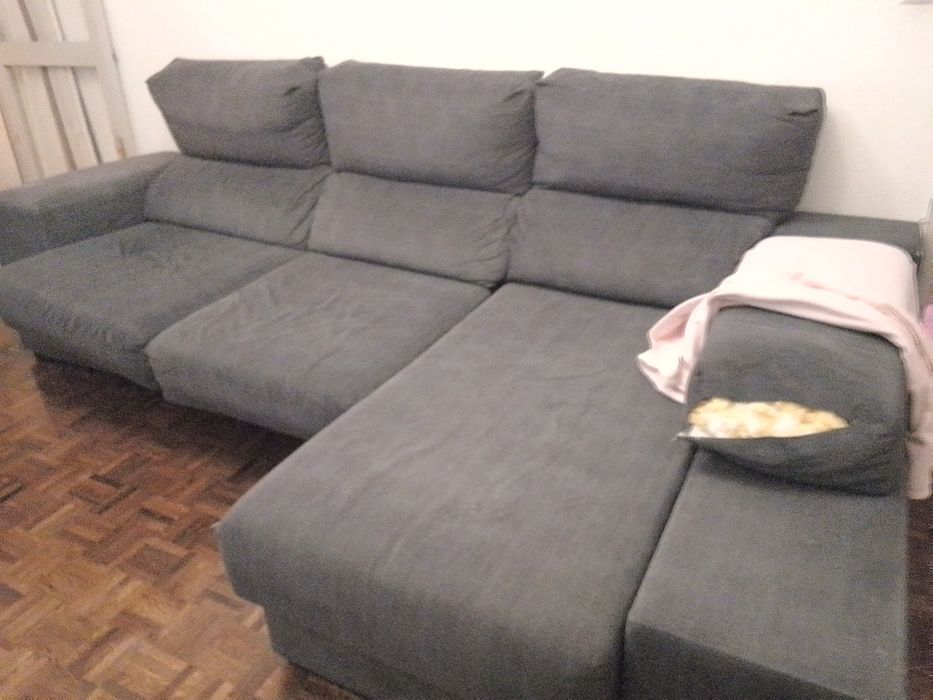 Sofá com chaise long e assentos deslizantes.