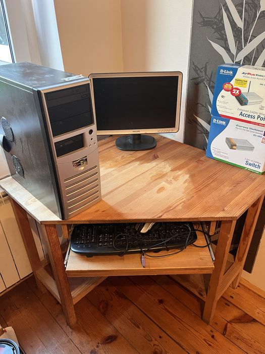 Biurko drewniane z komputerem i monitorem i routerem