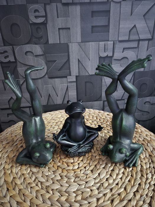 Trzy figurki żab w pozycji jogi.