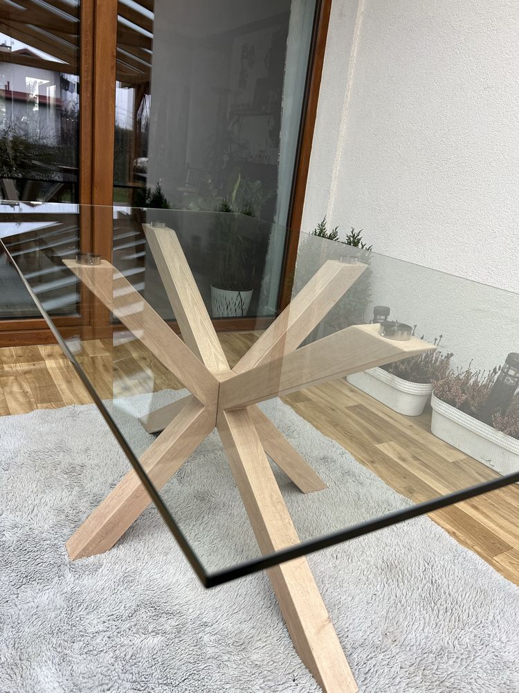 Stół szklany z metalową nogą