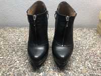 Botins pretos de salto alto com plataforma