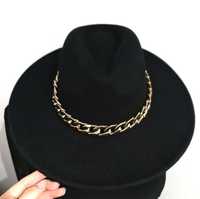 Czarny kapelusz z ozdobnym złotym łańcuchem
