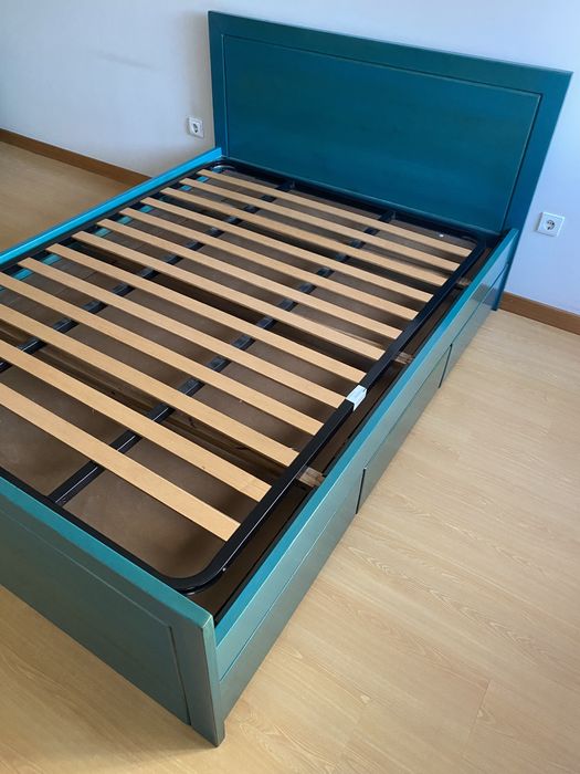 Cama em madeira de castanho pintada em azul a ver o veio da madeira