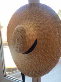 Солом‘яний капелюшок з широкими полями і стрічкою.
