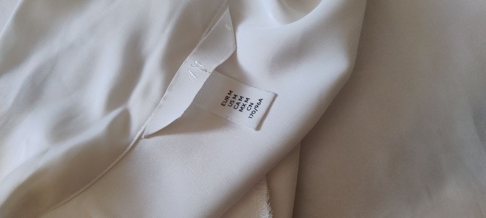 Szykowna, biała koszula z wiązaniem i makietami H&M