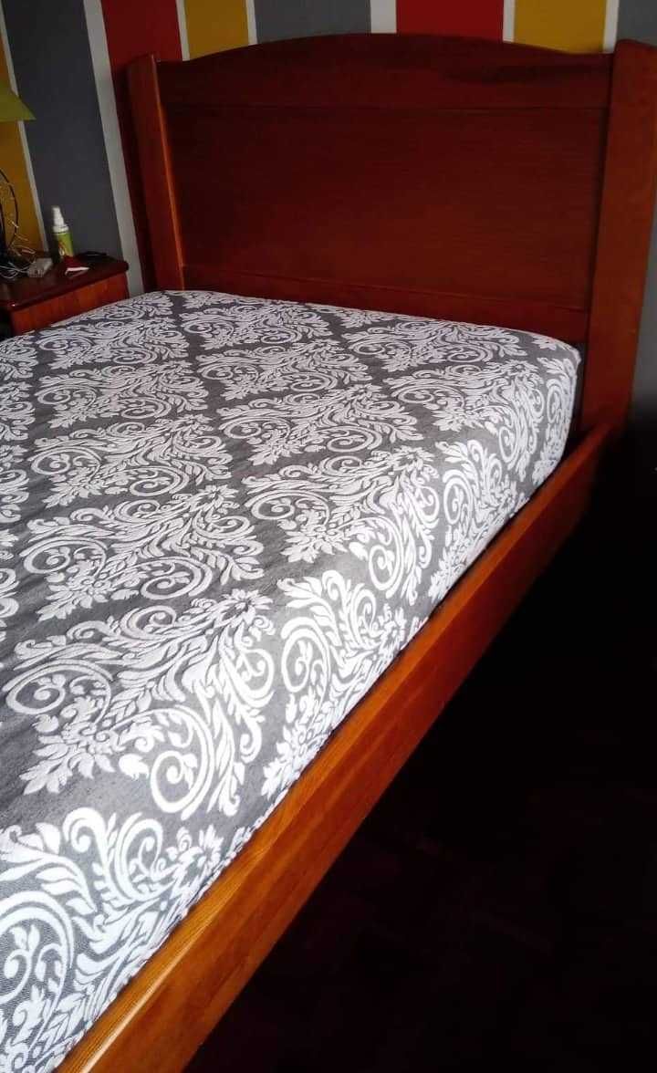 Cama em madeira maciça com colchão e mesa de cabeceira