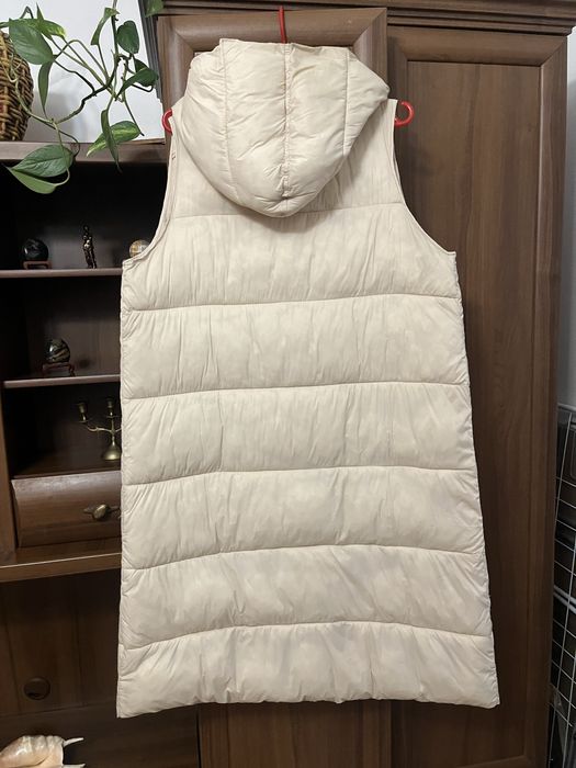 Безрукавка зимова, кремового кольору на закльопках