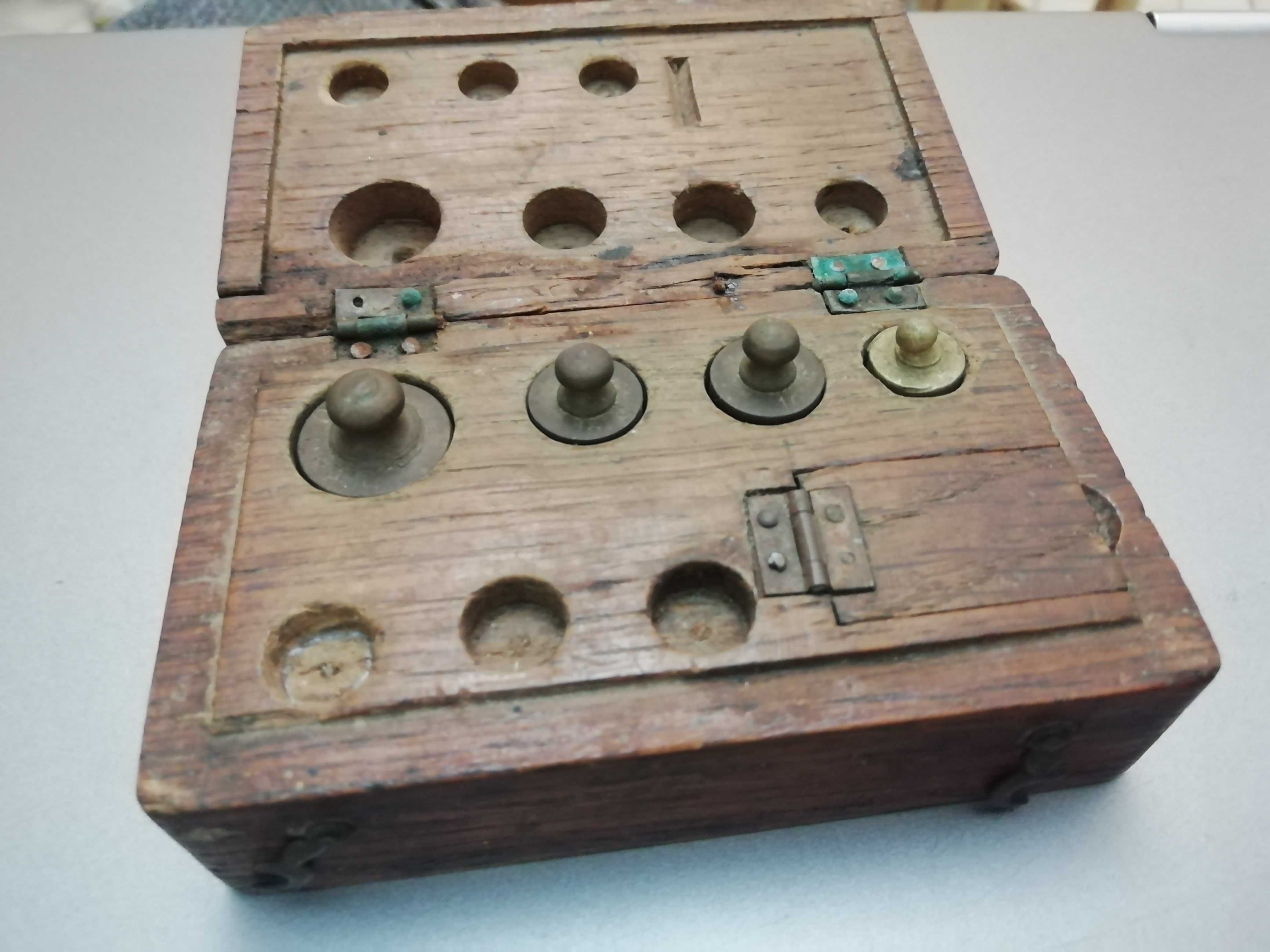 Caixa antiga com cepo de pesos pequenos de precisão