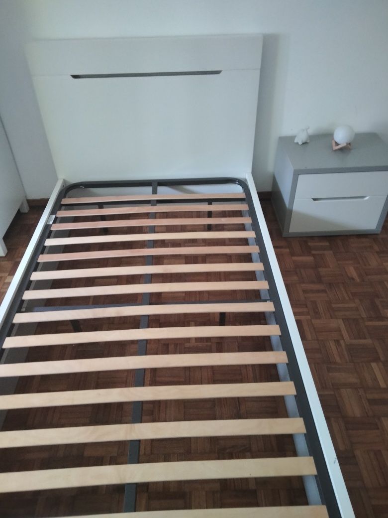 Cama branca e mesa de cabeceira