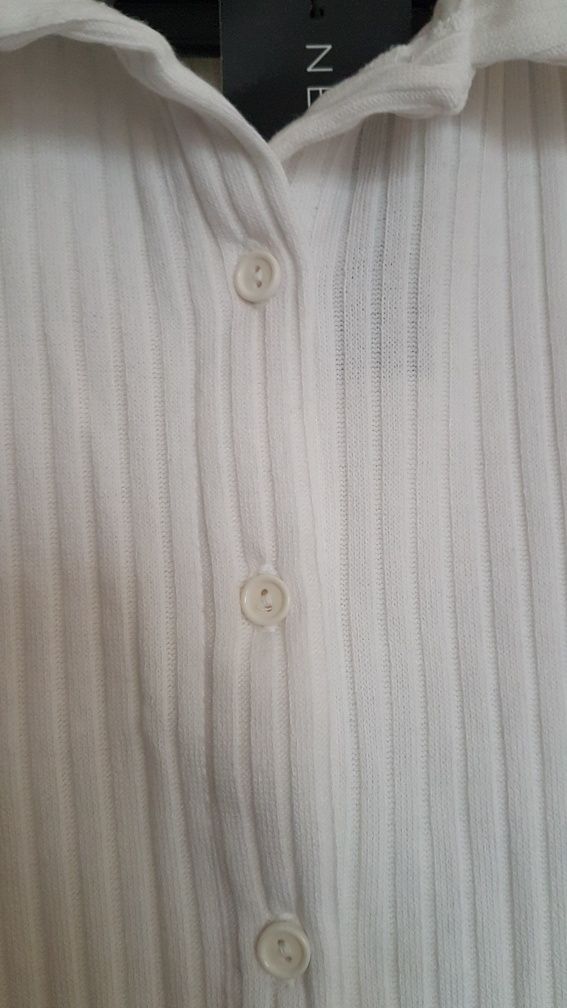 Biała bluzka z kolnierzykiem. Krótki rękaw.  Rozciagliwy wzór, prążki.