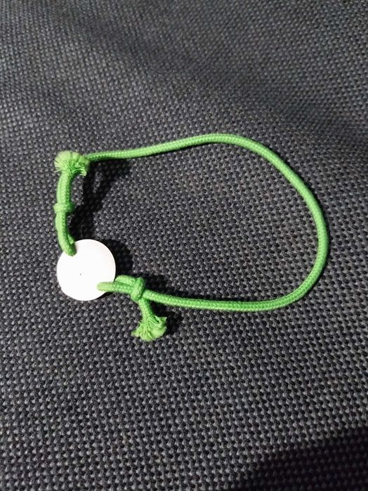 Pulseira de nós, verde, com mensagem “Por um mundo melhor”