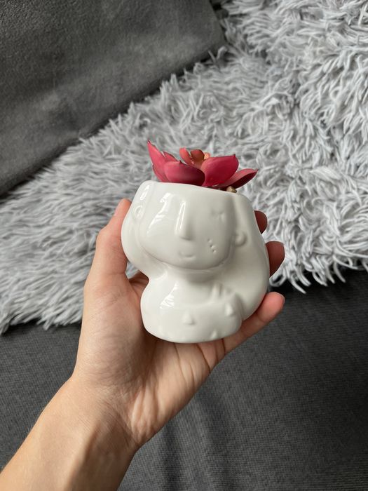 Ceramiczna doniczka w kształcie uroczego ludzika z małym sukulentem