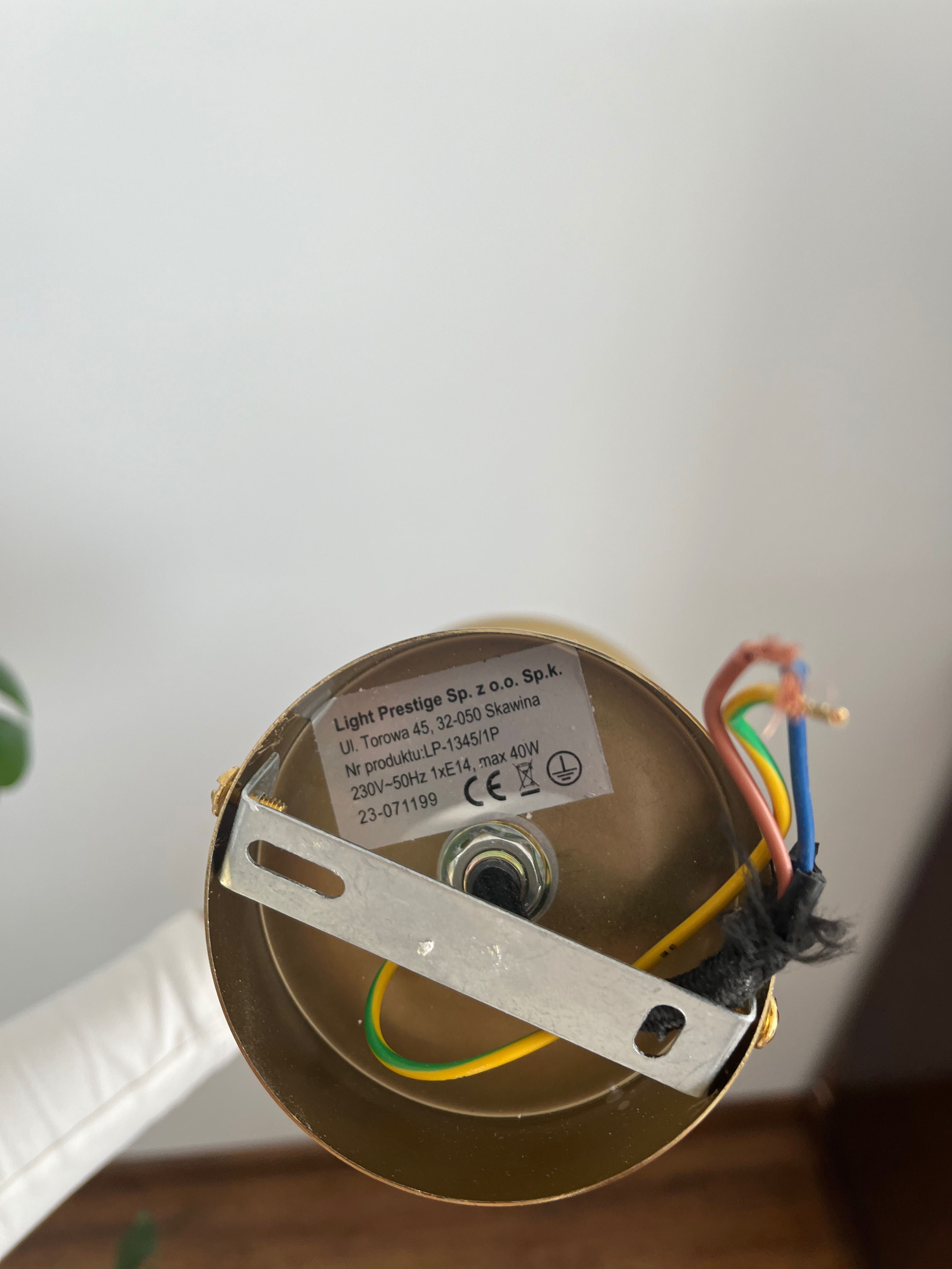 Złota lampa z białą kulą