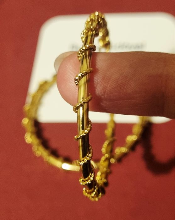 Brincos/argolas douradas, em aço, com cerca de 5cm de comprimento.