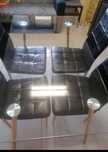 Mesa de vidro com 4 cadeiras.