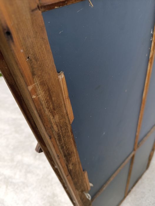 Lustro w starej drewnianej ramie okiennej.