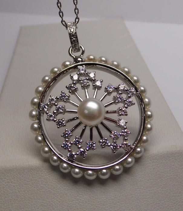 Srebrna zawieszka śnieżynka w kole perły i cyrkonie.