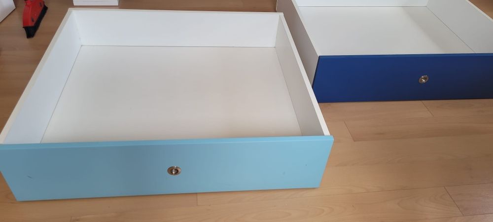 Cama com gavetões, colchão e cabide. Cores em tons de azul.