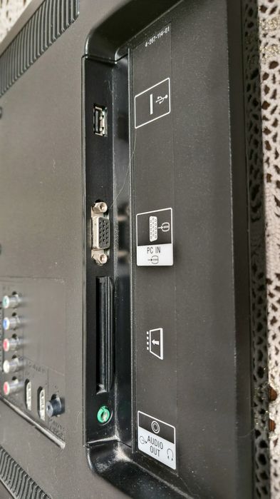 TV Sony z przystawką Google TV i uchwytem do ściany