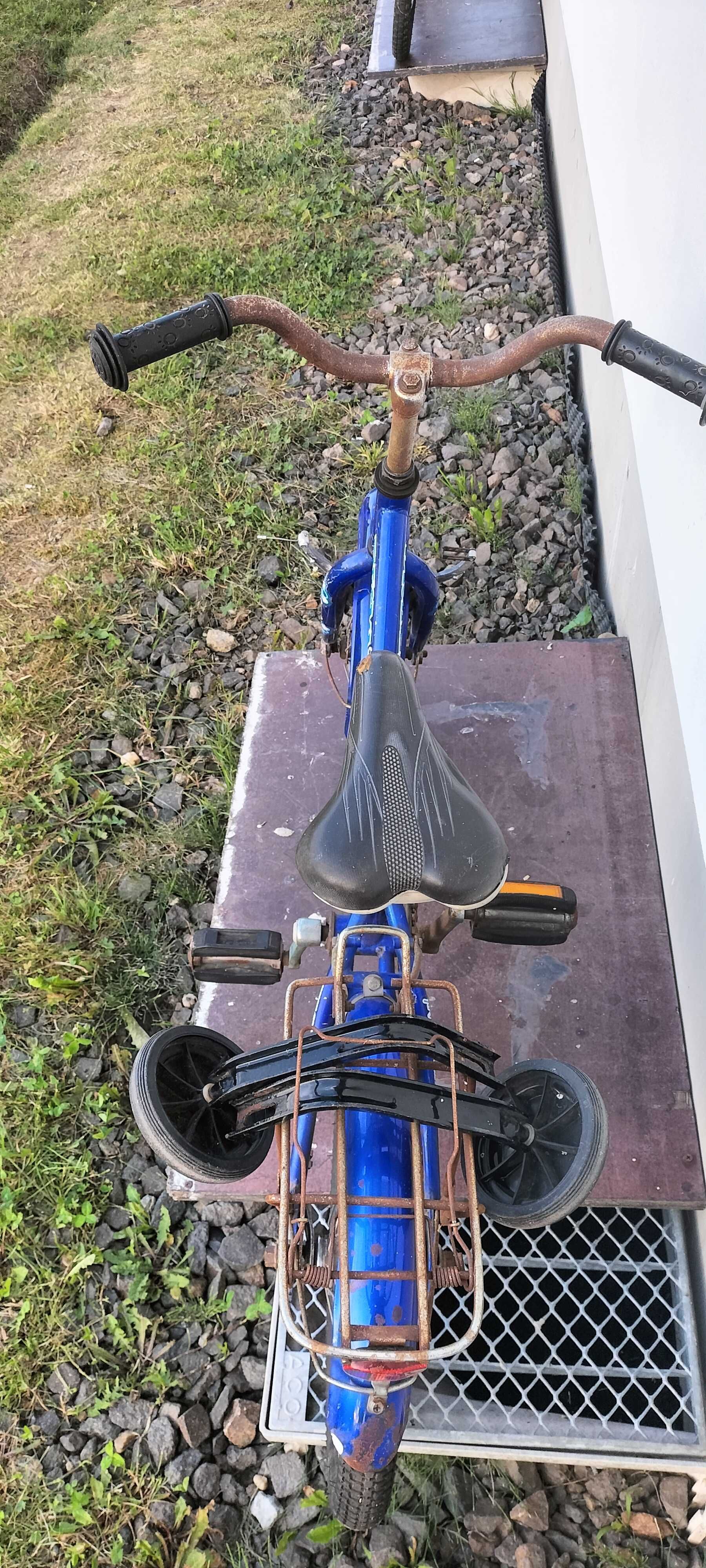 Rower dziecięcy z kółkami bocznymi.