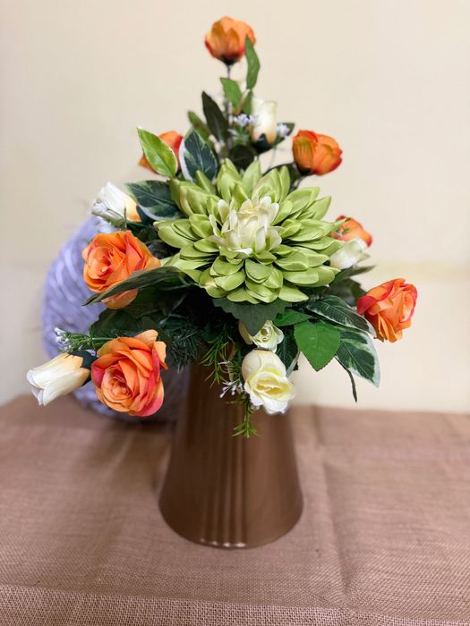 Kompozycja sztucznych kwiatów w wazonie.