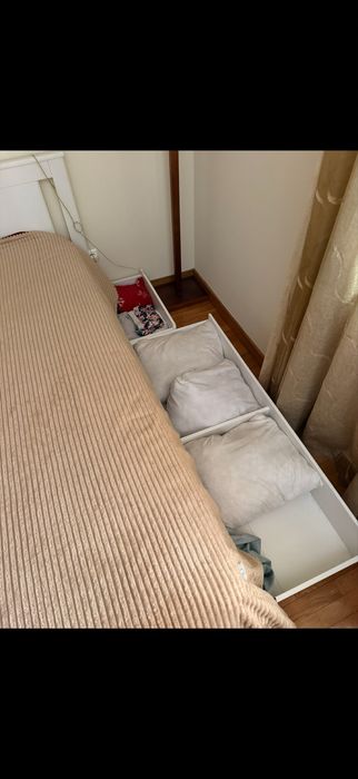 Cama branca de casal com arrumação