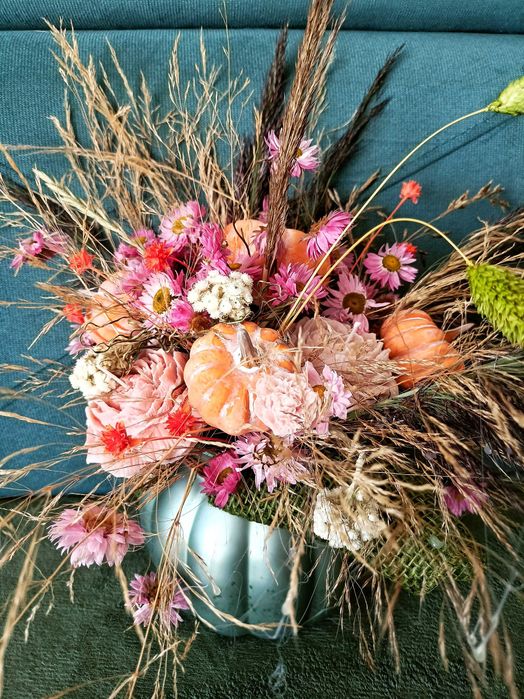 Jesienny stroik w szklanym wazonie dynia ze świecami sojowymi