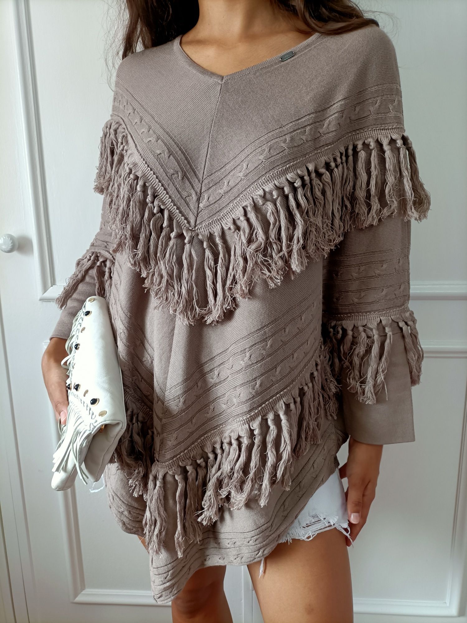 Camisola/poncho/capa com franjas da marca Ruga

Decote em V
Pormenor d