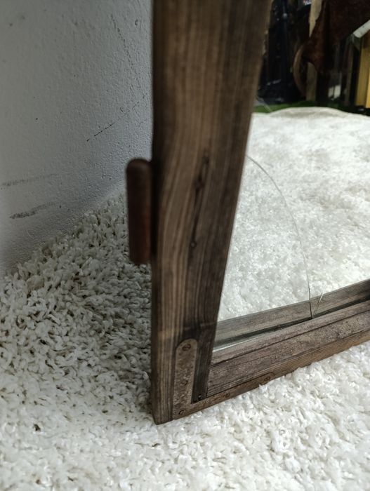 Lustro w starej drewnianej ramie okiennej.