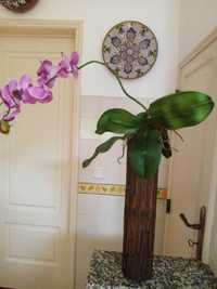 Orquídea artificial em tronco de madeira